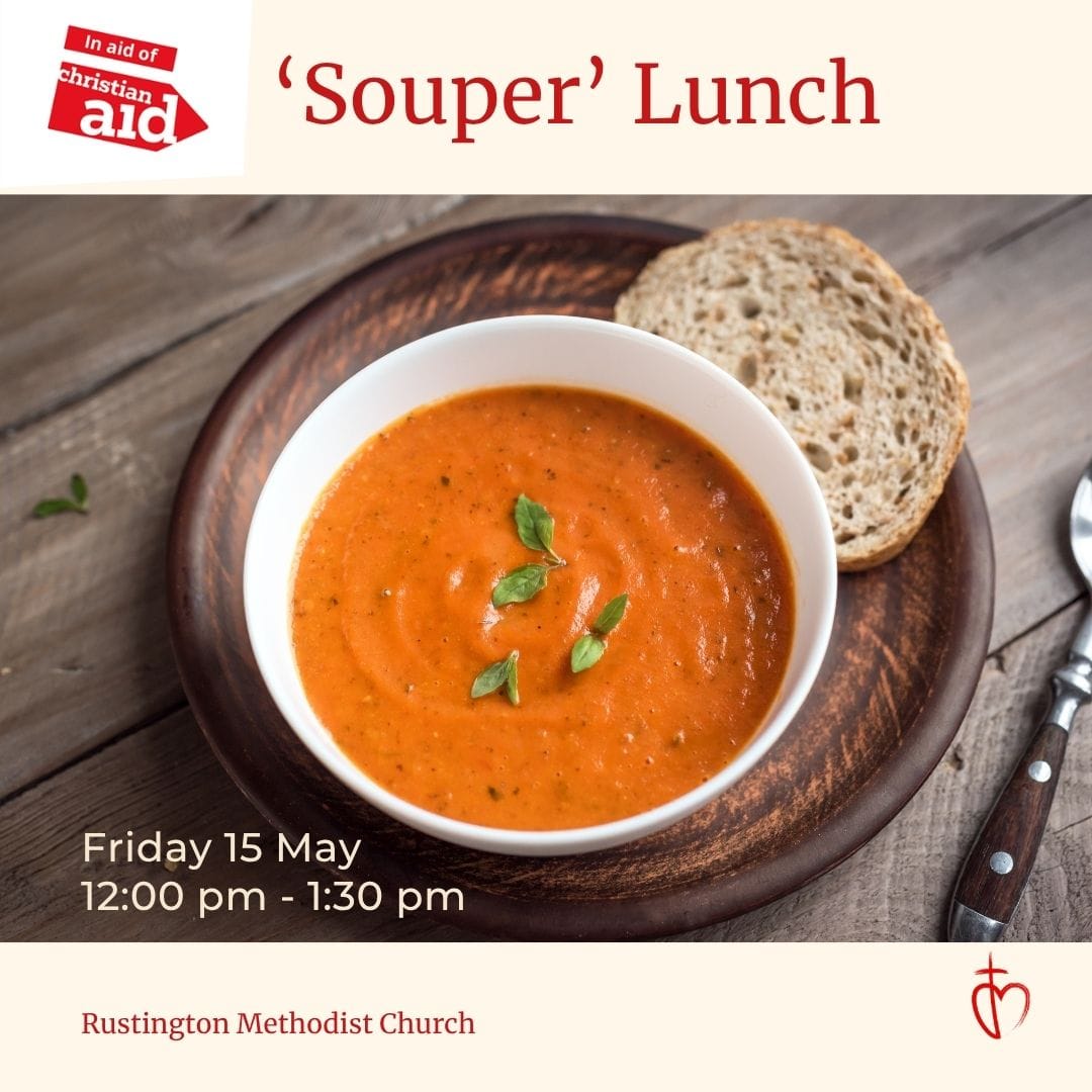 Photograph of a bowl of tomato soup garnished with basil leaves, served on a wooden plate with a slice of whole grain bread and a spoon on a wooden table. The promotional flyer announces a "Souper" Lunch event on Friday, May 15 from 12:00 pm to 1:30 pm at Rustington Methodist Church, supporting Christian Aid Week.